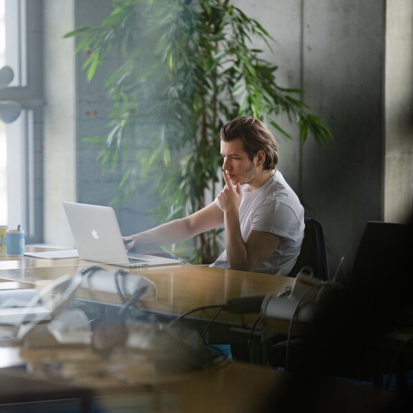 Am Laptop arbeitende Person / Nachdenklich und konzentriert