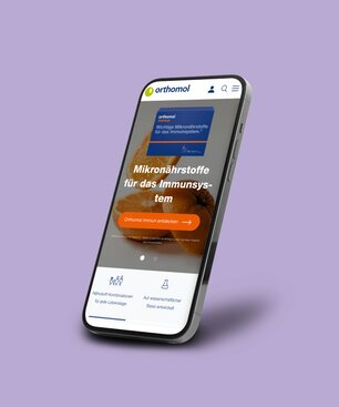 Ein Smartphone, auf dem eine Orthomol-Kundenreferenz aus dem Portfolio der Krankikom GmbH präsentiert wird.